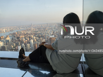 A woman is looking at the top view of New York City from the Summit One Vanderbilt observation deck in New York, U.S., on June 18, 2024. The...