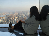 A woman is looking at the top view of New York City from the Summit One Vanderbilt observation deck in New York, U.S., on June 18, 2024. The...