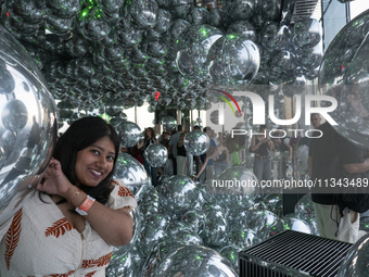 A woman is posing for a photograph at ''Affinity'' at Summit One Vanderbilt observation deck in New York, U.S., on June 18, 2024. The Summit...