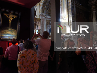 People are taking pictures of ''Dali's Christ'' at San Marcello al Corso Church in Rome, Italy, on June 19, 2024. Salvador Dali's famous pai...