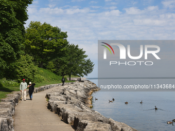 People are walking along a waterfront trail by Lake Ontario at Queen's Royal Park in Niagara-on-the-Lake, Ontario, Canada, on June 12, 2024....