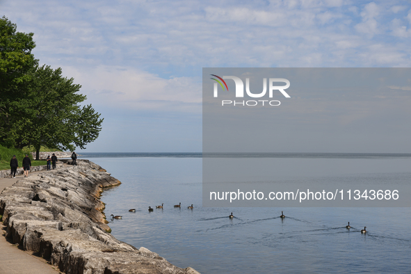 People are walking along a waterfront trail by Lake Ontario at Queen's Royal Park in Niagara-on-the-Lake, Ontario, Canada, on June 12, 2024....