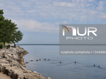 People are walking along a waterfront trail by Lake Ontario at Queen's Royal Park in Niagara-on-the-Lake, Ontario, Canada, on June 12, 2024....