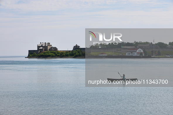 A man is kayaking along Lake Ontario past Old Fort Niagara in New York, USA, seen from Niagara-on-the-Lake, Ontario, Canada, on June 12, 202...