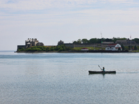 A man is kayaking along Lake Ontario past Old Fort Niagara in New York, USA, seen from Niagara-on-the-Lake, Ontario, Canada, on June 12, 202...