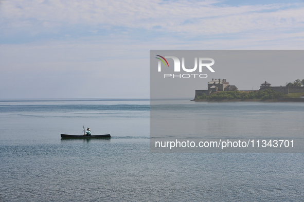 A man is kayaking along Lake Ontario past Old Fort Niagara in New York, USA, seen from Niagara-on-the-Lake, Ontario, Canada, on June 12, 202...