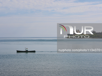 A man is kayaking along Lake Ontario past Old Fort Niagara in New York, USA, seen from Niagara-on-the-Lake, Ontario, Canada, on June 12, 202...