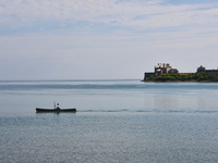 A man is kayaking along Lake Ontario past Old Fort Niagara in New York, USA, seen from Niagara-on-the-Lake, Ontario, Canada, on June 12, 202...