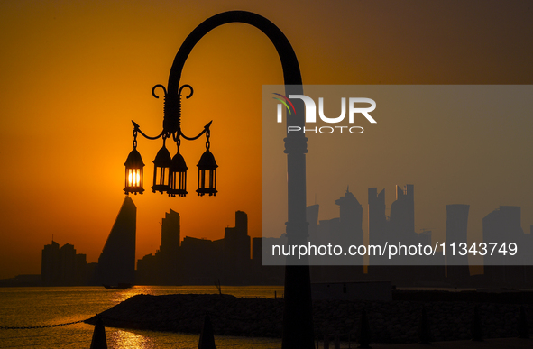 The sunset is illuminating the Doha skyline as seen from Old Doha Port in the warm weather in Doha, Qatar, on June 19, 2024. 