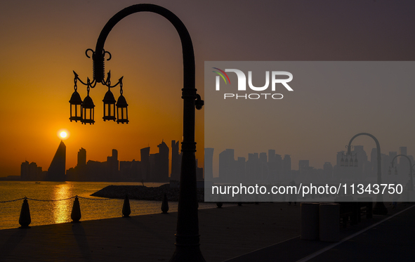 The sunset is illuminating the Doha skyline as seen from Old Doha Port in the warm weather in Doha, Qatar, on June 19, 2024. 