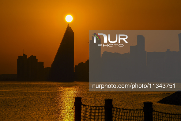 The sunset is illuminating the Doha skyline as seen from Old Doha Port in the warm weather in Doha, Qatar, on June 19, 2024. 