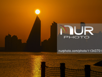 The sunset is illuminating the Doha skyline as seen from Old Doha Port in the warm weather in Doha, Qatar, on June 19, 2024. (