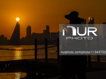 People are enjoying the sunset with the Doha skyline as seen from Old Doha Port in the warm weather in Doha, Qatar, on June 19, 2024. (