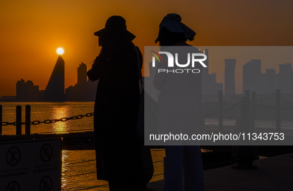 People are enjoying the sunset with the Doha skyline as seen from Old Doha Port in the warm weather in Doha, Qatar, on June 19, 2024. 