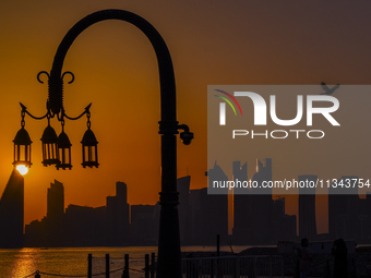 The sunset is illuminating the Doha skyline as seen from Old Doha Port in the warm weather in Doha, Qatar, on June 19, 2024. (