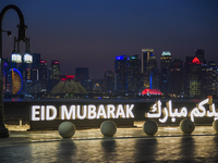 The Doha skyline is being seen behind an installation marking the Eid al-Adha celebrations 'EID MUBARAK' at Old Doha Port in Doha, Qatar, on...