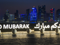 The Doha skyline is being seen behind an installation marking the Eid al-Adha celebrations 'EID MUBARAK' at Old Doha Port in Doha, Qatar, on...