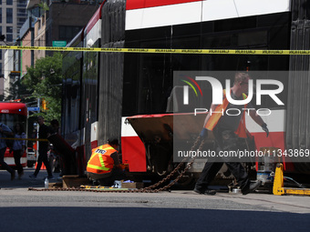 TTC workers are fixing a streetcar as it is stuck at King Street East and Church Street in Toronto, Canada, on June 19, 2024. (