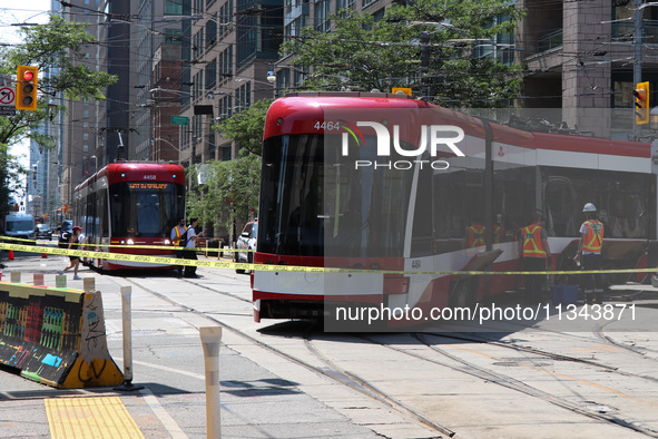 TTC workers are fixing a streetcar as it is stuck at King Street East and Church Street in Toronto, Canada, on June 19, 2024. 