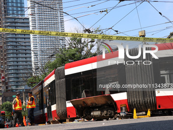 TTC workers are fixing a streetcar as it is stuck at King Street East and Church Street in Toronto, Canada, on June 19, 2024. (