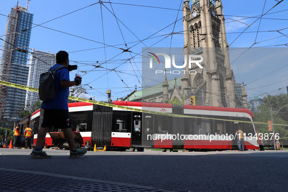 TTC workers are fixing a streetcar as it is stuck at King Street East and Church Street in Toronto, Canada, on June 19, 2024. 