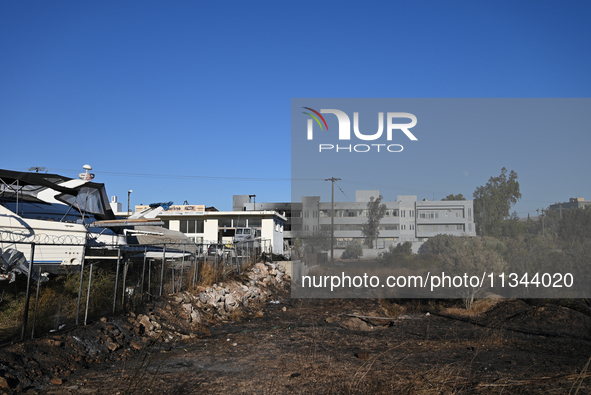 Industrial property is being damaged by a wildfire breaking out in Koropi near Athens, Greece, on June 19, 2024. 