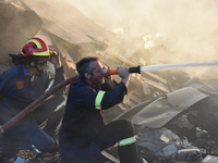 Firefighters are dropping water to extinguish a fire inside a container in Koropi near Athens, Greece, on June 19, 2024. (