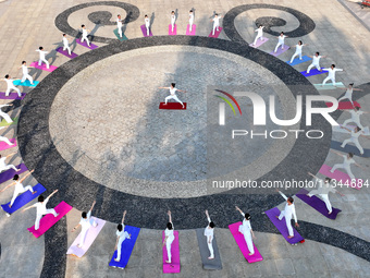 Yoga lovers are practicing yoga at Fengfeng Health Theme Cultural Park in Handan, China, on June 20, 2024. (