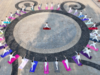 Yoga lovers are practicing yoga at Fengfeng Health Theme Cultural Park in Handan, China, on June 20, 2024. (