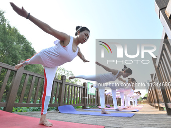 Yoga lovers are practicing yoga at Fengfeng Health Theme Cultural Park in Handan, China, on June 20, 2024. (