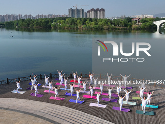 Yoga lovers are practicing yoga at Fengfeng Health Theme Cultural Park in Handan, China, on June 20, 2024. (