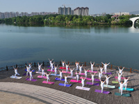 Yoga lovers are practicing yoga at Fengfeng Health Theme Cultural Park in Handan, China, on June 20, 2024. (