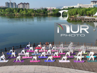 Yoga lovers are practicing yoga at Fengfeng Health Theme Cultural Park in Handan, China, on June 20, 2024. (