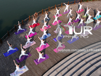 Yoga lovers are practicing yoga at Fengfeng Health Theme Cultural Park in Handan, China, on June 20, 2024. (