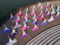 Yoga lovers are practicing yoga at Fengfeng Health Theme Cultural Park in Handan, China, on June 20, 2024. (