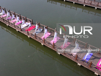 Yoga lovers are practicing yoga at Fengfeng Health Theme Cultural Park in Handan, China, on June 20, 2024. (