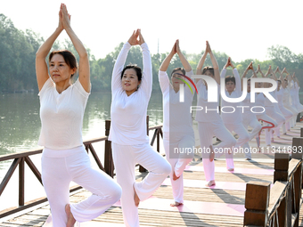 Yoga lovers are practicing yoga at Fengfeng Health Theme Cultural Park in Handan, China, on June 20, 2024. (