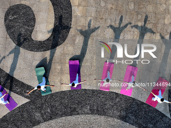 Yoga lovers are practicing yoga at Fengfeng Health Theme Cultural Park in Handan, China, on June 20, 2024. (