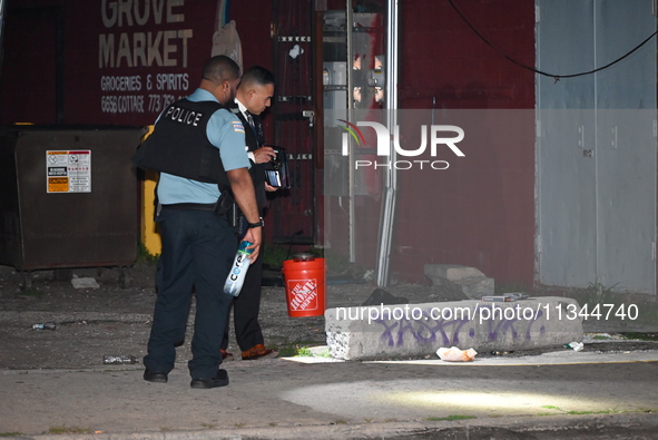 Police officers are investigating at the crime scene. One person is killed and another is injured in a shooting in Chicago, Illinois, United...