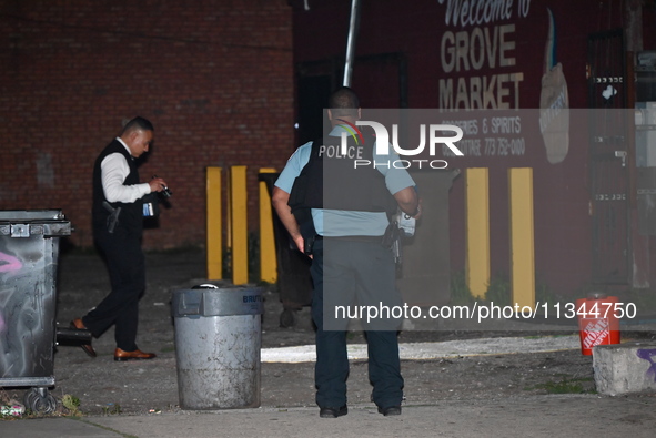 Police officers are investigating at the crime scene. One person is killed and another is injured in a shooting in Chicago, Illinois, United...