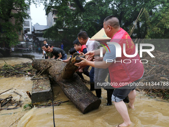 Villagers are braving the rain to clean branches stuck on a bridge in Banlan township, Rongan County, Liuzhou city, South China's Guangxi Zh...