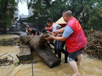 Villagers are braving the rain to clean branches stuck on a bridge in Banlan township, Rongan County, Liuzhou city, South China's Guangxi Zh...