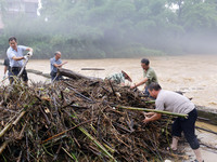 Villagers are braving the rain to clean branches stuck on a bridge in Banlan township, Rongan County, Liuzhou city, South China's Guangxi Zh...