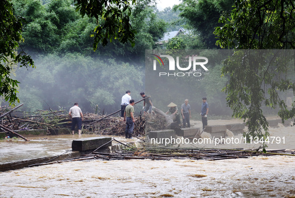 Villagers are braving the rain to clean branches stuck on a bridge in Banlan township, Rongan County, Liuzhou city, South China's Guangxi Zh...