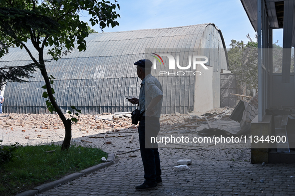 A man is looking at damage done by a nighttime Russian kamikaze drone attack to the State Research Control Institute of Veterinary Medicinal...