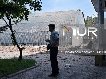 A man is looking at damage done by a nighttime Russian kamikaze drone attack to the State Research Control Institute of Veterinary Medicinal...