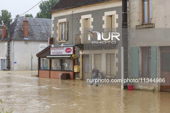 A man is standing in front of his bakery after rising waters in Narcy, France, on June 20, 2024. 