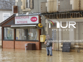 A man is standing in front of his bakery after rising waters in Narcy, France, on June 20, 2024. (