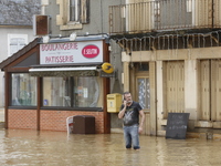 A man is standing in front of his bakery after rising waters in Narcy, France, on June 20, 2024. (