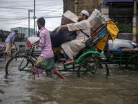 People are moving through a flooded street in Sylhet city, Sylhet, Bangladesh, on Thursday, June 20, 2024. In Sylhet, lashing rain and river...